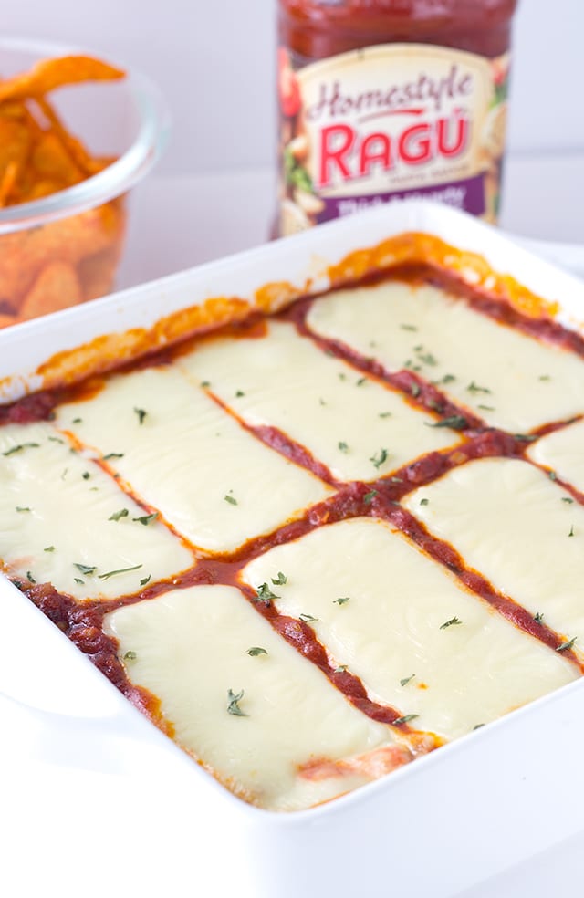 This lasagna dip recipe is a must make party dip. It's a hearty dip with 3 kinds of cheese and sausage and can be served with toasted baguette slices or chips! warm dip with ricotta, mozzarella, and parmesan cheeses as well as hot sausage and Ragu sauce