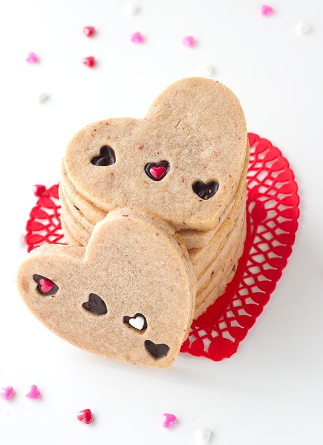 Strawberry Sugar Cookies - Delicious cut-out strawberry flavored sugar cookies with little heart cut outs that are filled with milk chocolate. The perfect Valentine's Day treat!