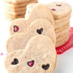 Strawberry Sugar Cookies - Delicious cut-out strawberry flavored sugar cookies with little heart cut outs that are filled with milk chocolate. The perfect Valentine's Day treat!