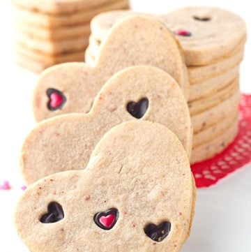 Strawberry Sugar Cookies - Delicious cut-out strawberry flavored sugar cookies with little heart cut outs that are filled with milk chocolate. The perfect Valentine's Day treat!