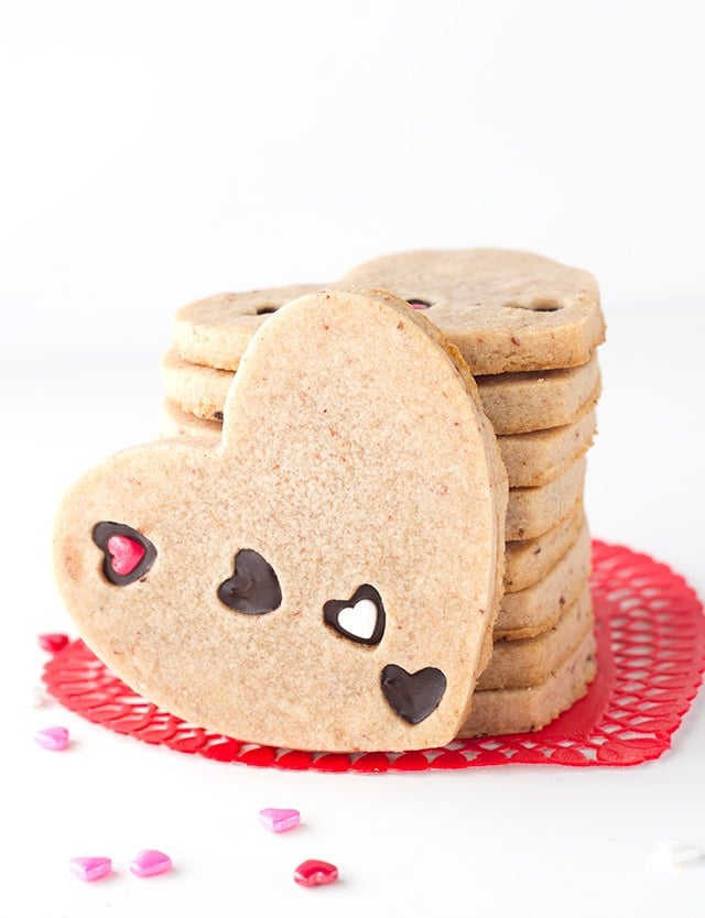 Strawberry Sugar Cookies - Delicious cut-out strawberry flavored sugar cookies with little heart cut outs that are filled with milk chocolate. The perfect Valentine's Day treat!