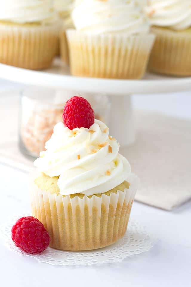 Coconut Cupcakes - coconut cupcakes stuffed with a homemade raspberry filling and topped with a high coconut frosting swirl