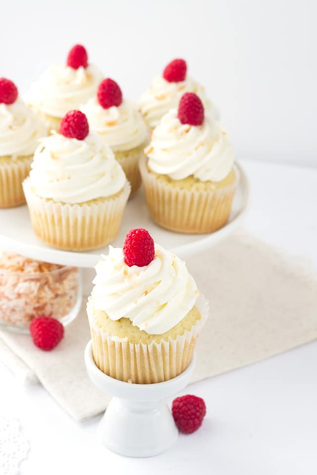 Coconut Cupcakes - coconut cupcakes stuffed with a homemade raspberry filling and topped with a high coconut frosting swirl