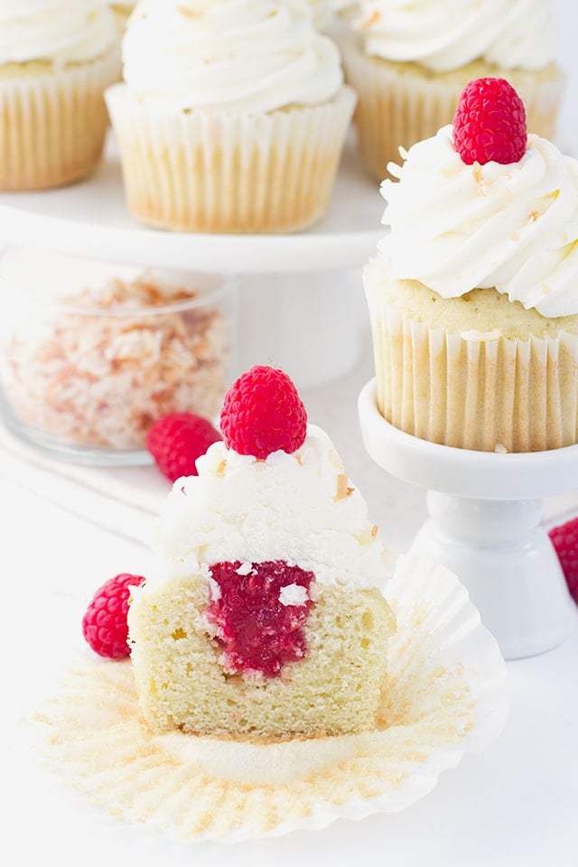 Coconut Cupcakes - coconut cupcakes stuffed with a homemade raspberry filling and topped with a high coconut frosting swirl