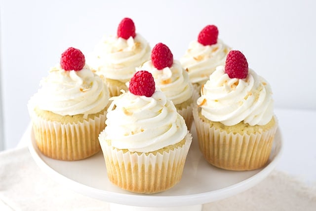 Coconut Cupcakes - coconut cupcakes stuffed with a homemade raspberry filling and topped with a high coconut frosting swirl