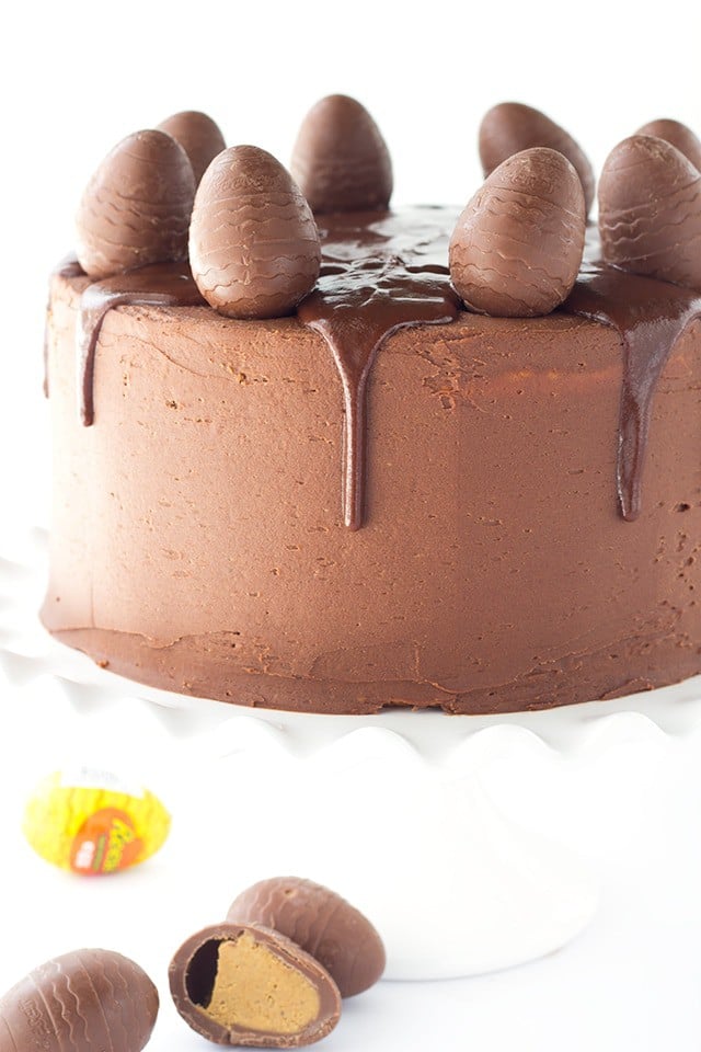 Peanut Butter Cake with Chocolate Frosting - peanut butter cake filled with chocolate frosting and chopped peanut butter cups. Top this cake with a chocolate peanut butter ganache and cute peanut butter filled chocolate eggs for EASTER! 