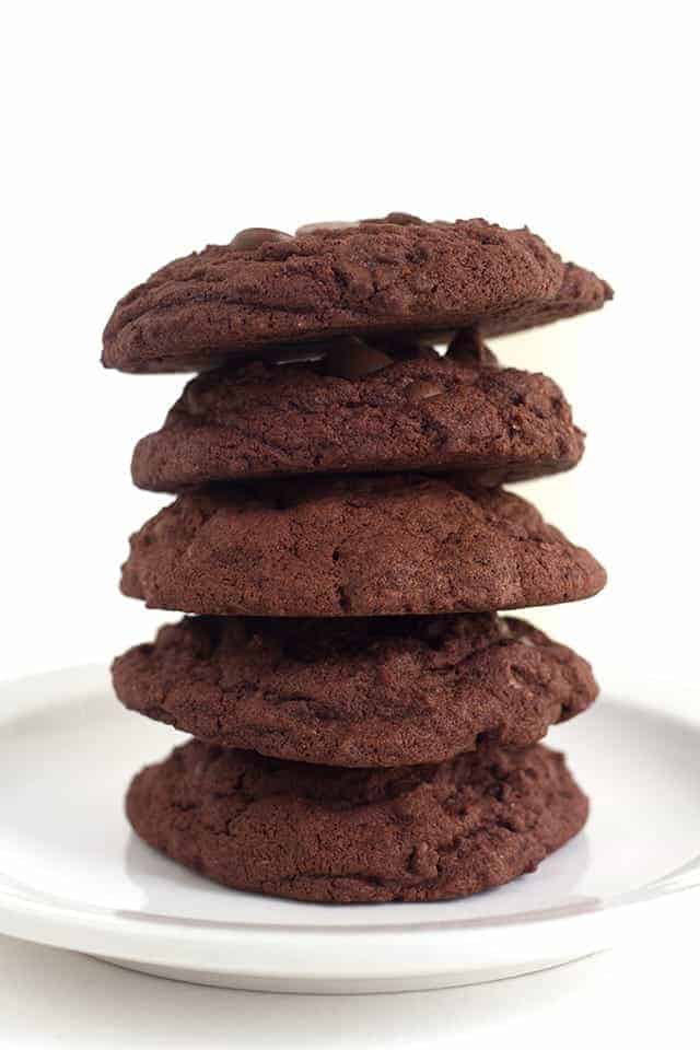 A stack of double chocolate chip pudding cookies on a white plate