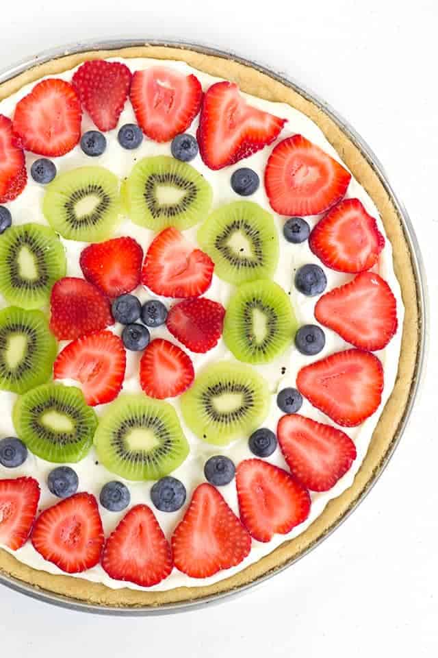 Easy Fruit Pizza - layers of sugar cookie, lemony cream cheese, and freshly sliced fruit! It's the perfect summer dessert pizza!