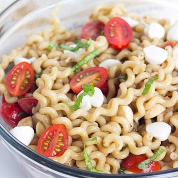 clear glass bowl full of Caprese Pasta Salad