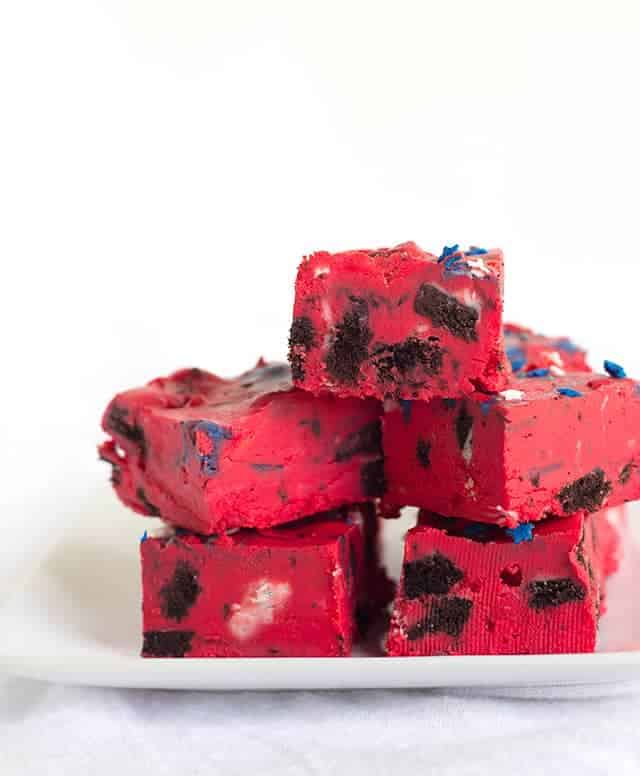 Oreo Frosting Fudge - easy fudge made with white chocolate chips, red store-bought frosting, and stuffed with popping oreos and star sprinkles.