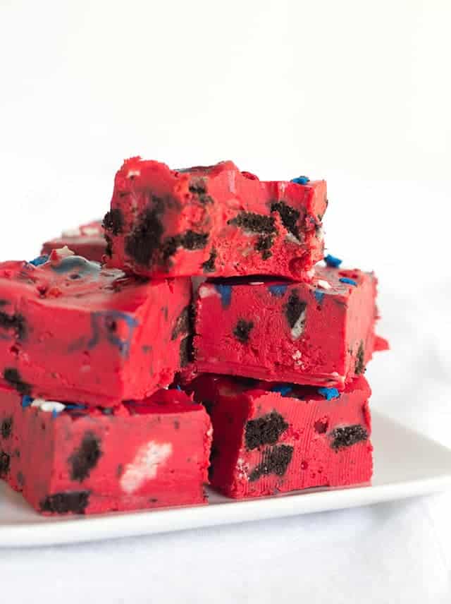 Oreo Frosting Fudge - easy fudge made with white chocolate chips, red store-bought frosting, and stuffed with popping oreos and star sprinkles.