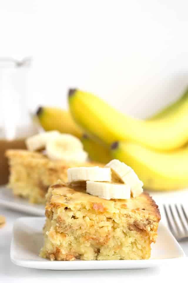slice of bananas foster pancake casserole on a white plate with bananas