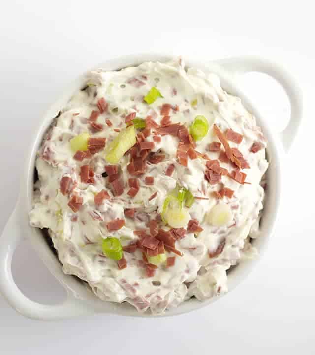 Chipped Beef Dip - This chipped beef dip recipe makes an amazing appetizer for any party. It has dried beef, green onions, and peperoncini in it. It goes great with veggies and bread! This is an easy chip beef recipe that uses dried beef. #appetizer #diprecipe #gamedayrecipes #gamedayfood #partyfood bowl of Chipped Beef Dip with Peperoncini
