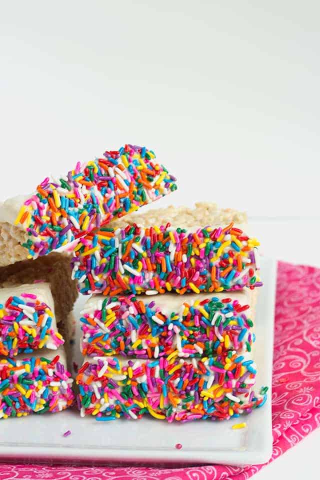 Chocolate Dipped Rice Krispie Treats on a plate with a pink fabric