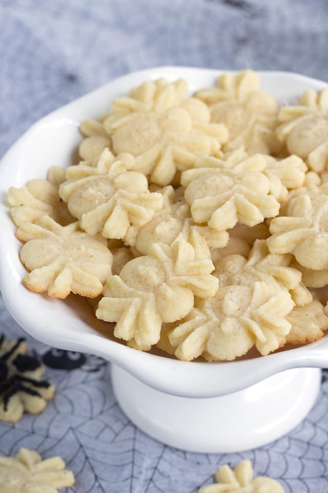 spider spritz cookies in a white serving bowl and spiderweb tissue paper