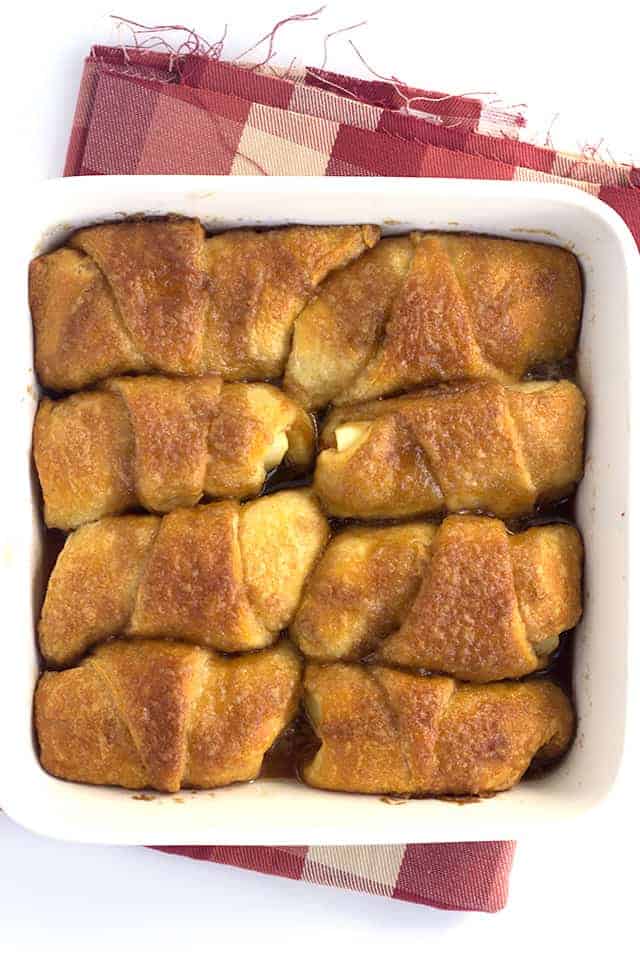 Crescent Roll Apple Dumplings - slices of apples rolled up in crescent rolls with cinnamon and sugar. Once everything is in the pan, it's coated with a layer of a buttery cinnamon brown sugar mixture and baked.