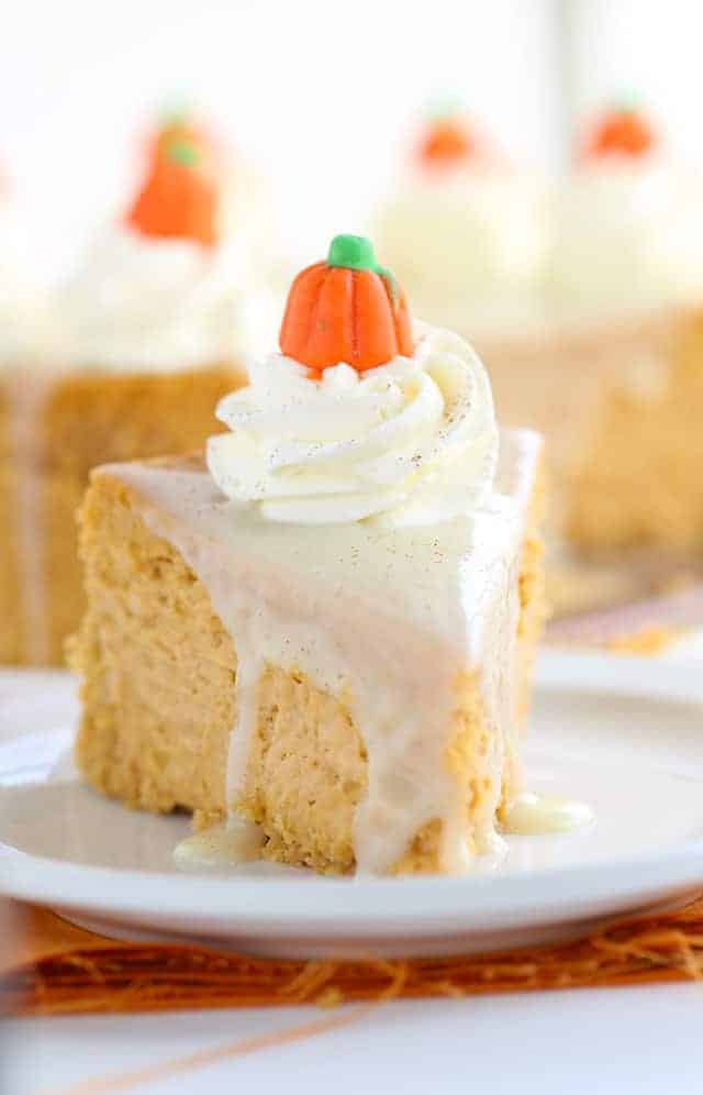 Pumpkin Cheesecake - Thick, creamy cheesecake stuffed full of all the right spices for a pumpkin pie! To finish the pumpkin cheesecake off, I added a maple white chocolate ganache, whipped cream, a dusting of cinnamon, and cute little candy pumpkins! This would be a hit for Thanksgiving dessert!
