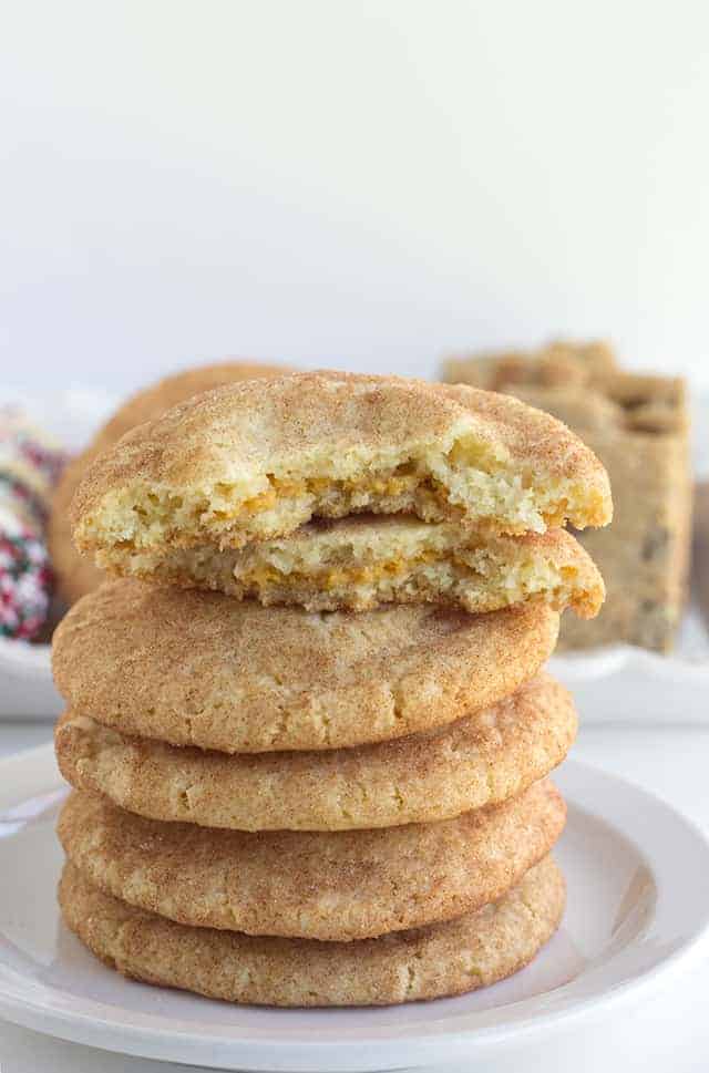 Pumpkin Cheesecake Snickerdoodles - These cookies are the perfect shortcut cookies for a holiday cookie tray.. They are stuffed with a creamy pumpkin cheesecake filling that adds an additional bit of flavor! The outside is slightly crunchy from the cinnamon sugar coating.