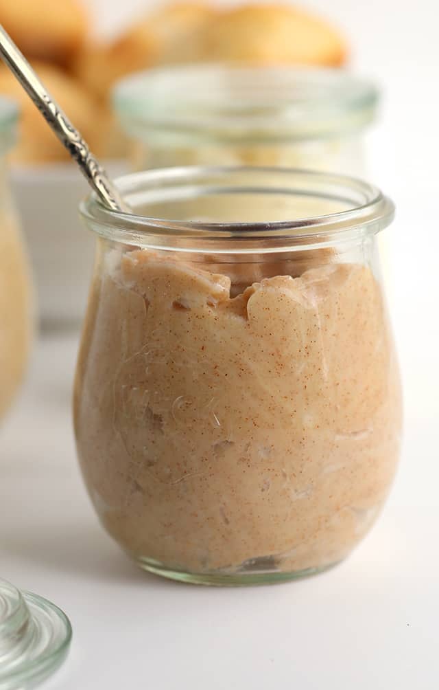 compound butter in a glass jar with a spoon, now infused with cinnamon and sugar.
