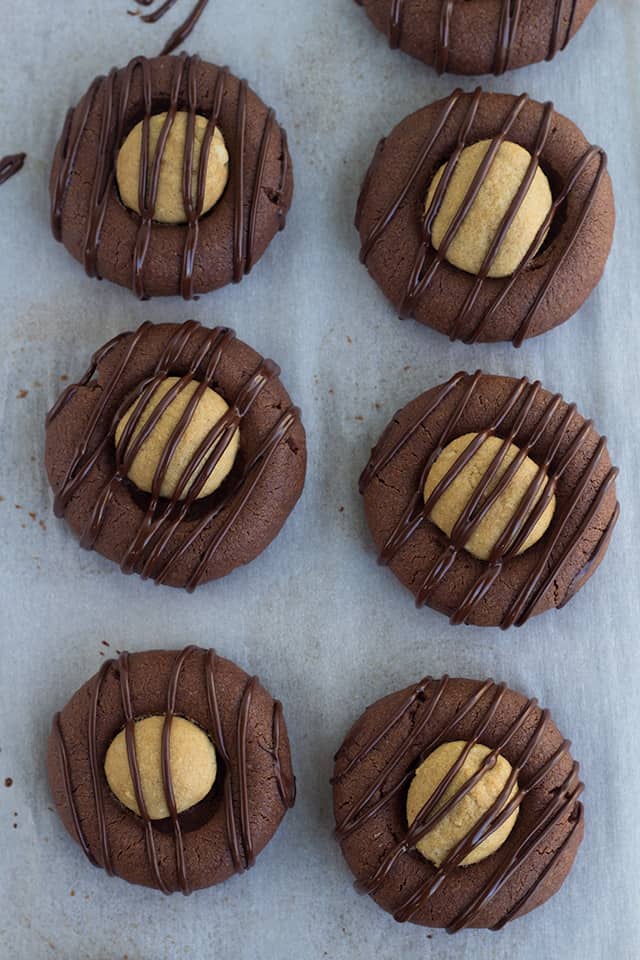 overhead photo of thumbprint cookies on a parchment paper lined baking sheet