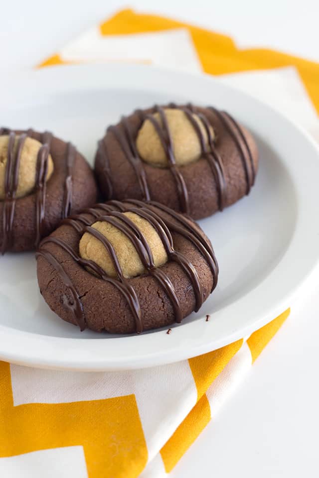 3 cookies on a white plate with a yellow chevron fabric under the plate