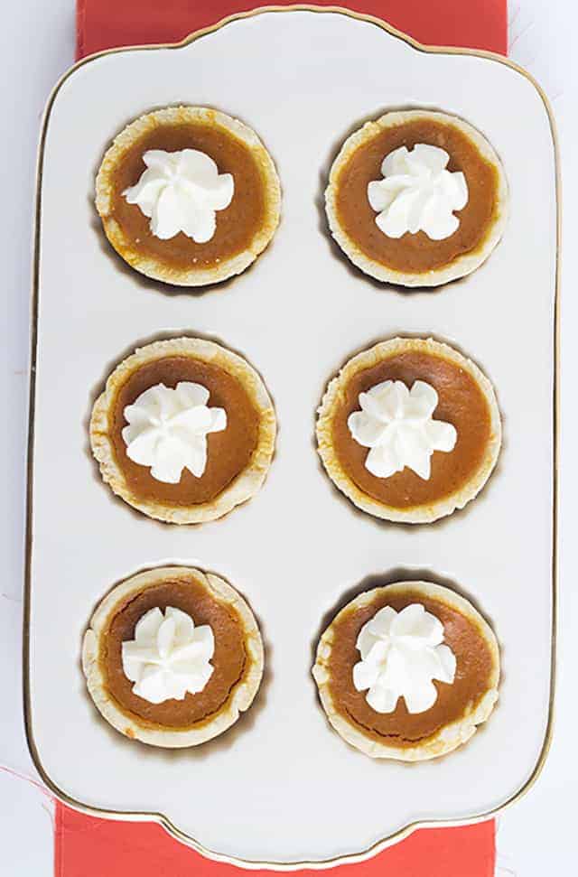 Mini Maple Pumpkin Pies - these adorable mini pumpkin pies have a hint of maple and loads of pumpkin spice! Top them with some fresh whipped cream and serve them at your next Thanksgiving get-together!