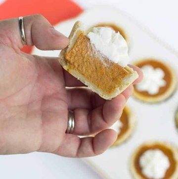 A hand holding a Mini Maple Pumpkin Pie.