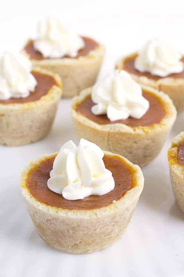 Mini Maple Pumpkin Pies - these adorable mini pumpkin pies have a hint of maple and loads of pumpkin spice! Top them with some fresh whipped cream and serve them at your next Thanksgiving get-together!