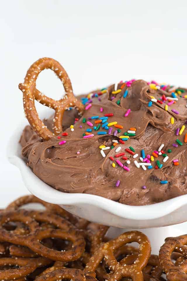 Chocolate pretzel dip in a white bowl with sprinkles, resembling brownie batter.