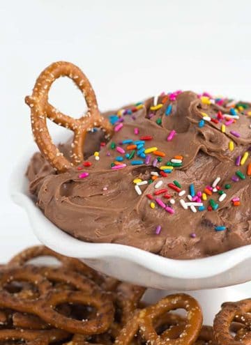 A bowl of brownie batter dip with pretzel in it.