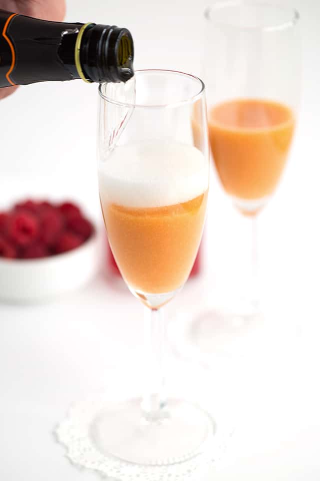 Peach Raspberry Bellini - raspberry infused simple syrup, peach puree, and sparkling wine come together to make a great fruity bellini! This is a drink for any and all occasions!