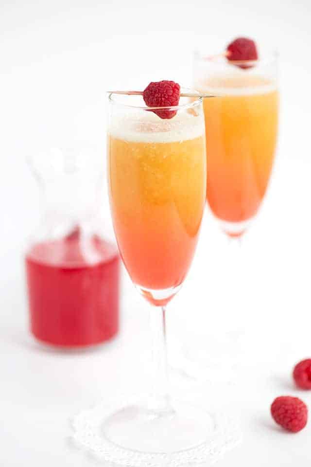 Peach Raspberry Bellini - raspberry infused simple syrup, peach puree, and sparkling wine come together to make a great fruity bellini! This is a drink for any and all occasions!