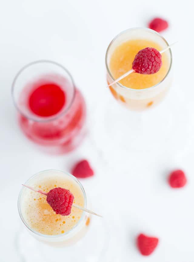 Peach Raspberry Bellini - raspberry infused simple syrup, peach puree, and sparkling wine come together to make a great fruity bellini! This is a drink for any and all occasions!