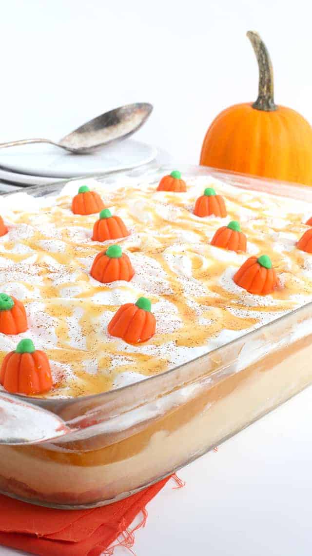 Pumpkin Butterscotch Layer Dessert - Layers of crushed vanilla sandwich cookies, pumpkin cheesecake, butterscotch pudding, whipped topping, and adorable candy pumpkins! This screams the perfect Fall and Thanksgiving dessert! It's so simple to make too!