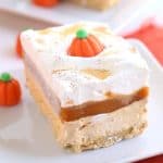Pumpkin Butterscotch Layer Dessert - Layers of crushed vanilla sandwich cookies, pumpkin cheesecake, butterscotch pudding, whipped topping, and adorable candy pumpkins! This screams the perfect Fall and Thanksgiving dessert! It's so simple to make too!