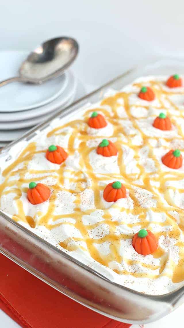 Pumpkin Butterscotch Layer Dessert - Layers of crushed vanilla sandwich cookies, pumpkin cheesecake, butterscotch pudding, whipped topping, and adorable candy pumpkins! This screams the perfect Fall and Thanksgiving dessert! It's so simple to make too!