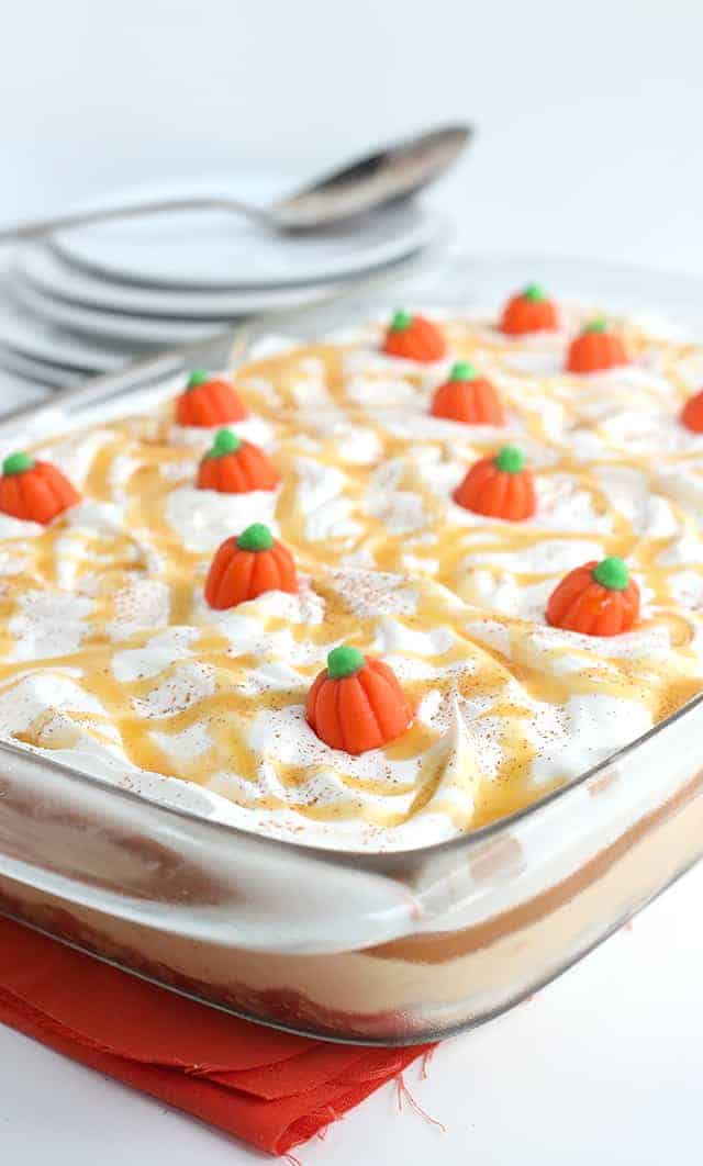 Pumpkin Butterscotch Layer Dessert - Layers of crushed vanilla sandwich cookies, pumpkin cheesecake, butterscotch pudding, whipped topping, and adorable candy pumpkins! This screams the perfect Fall and Thanksgiving dessert! It's so simple to make too!