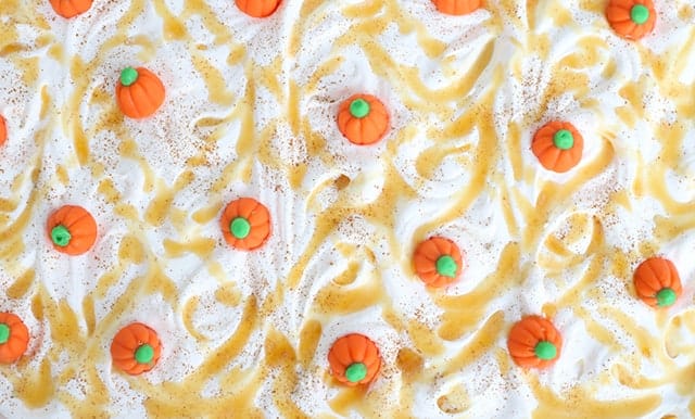 Pumpkin Butterscotch Layer Dessert - Layers of crushed vanilla sandwich cookies, pumpkin cheesecake, butterscotch pudding, whipped topping, and adorable candy pumpkins! This screams the perfect Fall and Thanksgiving dessert! It's so simple to make too!