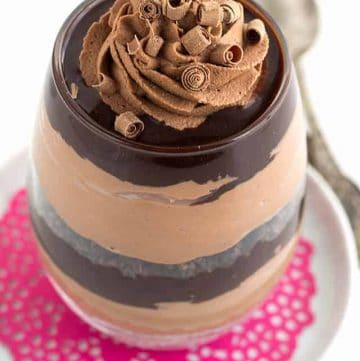 Two chocolate trifle bowls on pink plates.