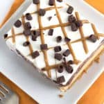 A dessert consisting of a cookie butter layer and chocolate peanut butter ice cream cake on a plate.