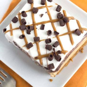 A dessert consisting of a cookie butter layer and chocolate peanut butter ice cream cake on a plate.