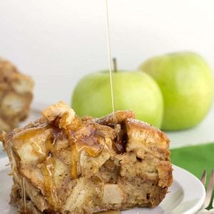 A slice of apple bread pudding is being drizzled with caramel sauce, reminiscent of Apple Cinnamon French Toast.