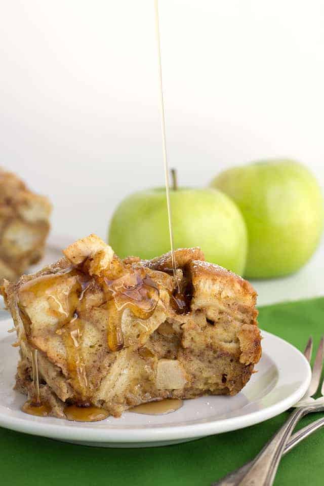 Slice of apple cinnamon french toast with maple syrup being poured on top of it.