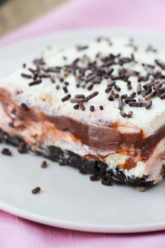 Upclose picture of the front of a slice of chocolate layer dessert on a white plate