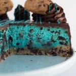 A Cookie Monster-inspired blue cheesecake with chocolate chip cookies on a plate.