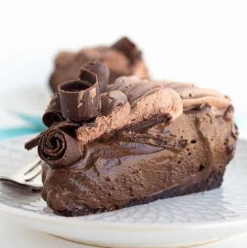 A slice of chocolate cheesecake with a creamy texture, sitting on a plate.