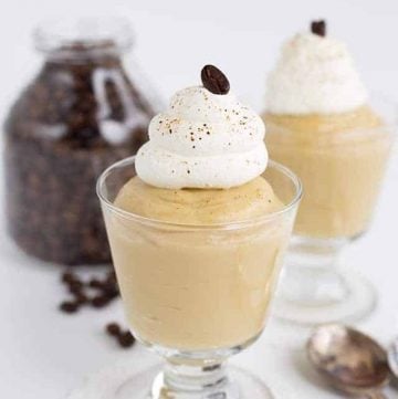 Rich and indulgent coffee pudding topped with fluffy whipped cream and garnished with aromatic coffee beans.