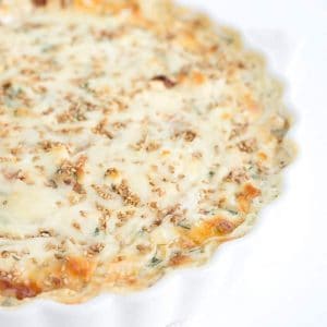 A white quiche with cheese and spinach.