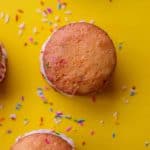 Four whoopie pies with sprinkles on a yellow background.