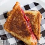 Cherry mountain pie cut in half on a black and white plaid plate